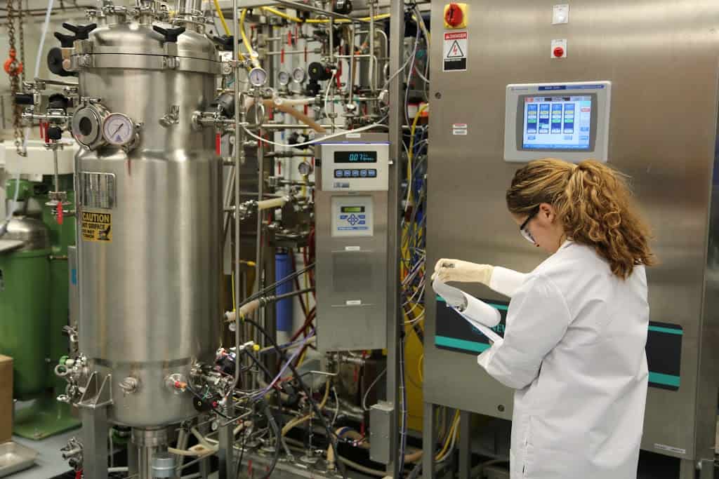Científica manejando un fermentador industrial.
